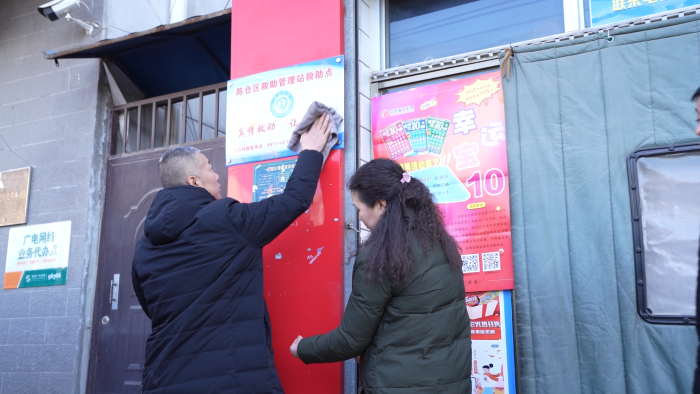 赵军斌和爱人擦拭陈仓区救助管理站救助点标牌